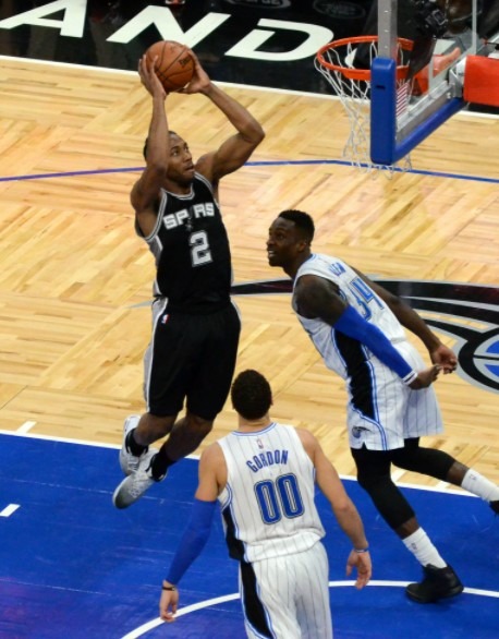 man shooting the ball, two men wearing white jersey uniform, basketball court
