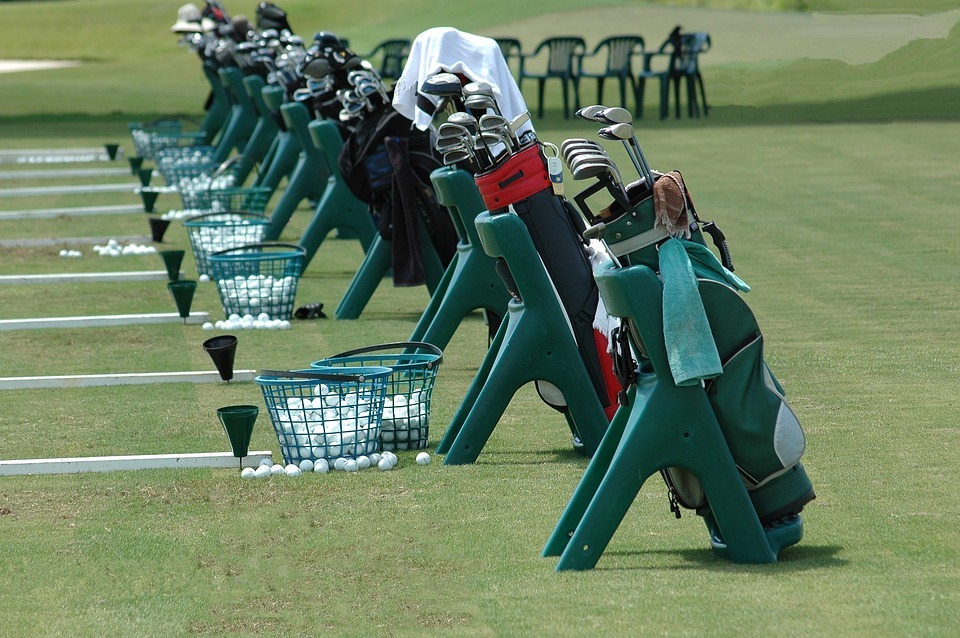 green baskets filled with golf balls, golf bags, golf clubs