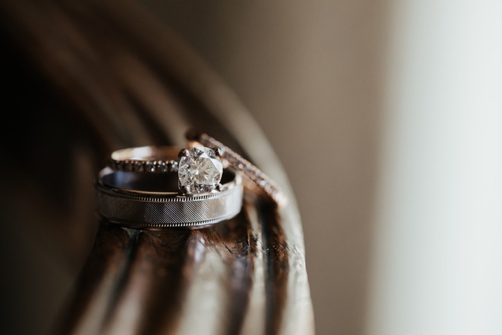 Two wedding bands close up - diamond engagement ring and silver wedding band