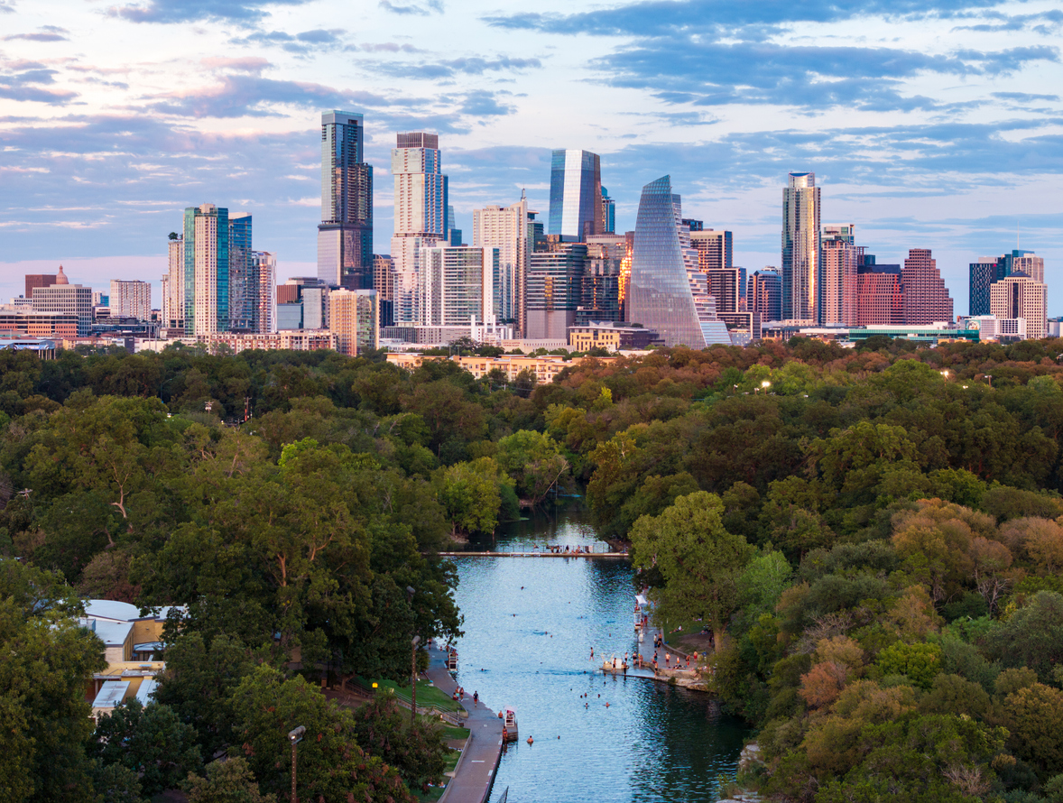 Aerial drone view of the Austin Texas skyline at sunset seen from above the Barton Springs swimming pool
