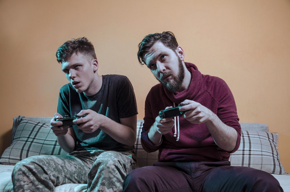 Zombie like video gamers indoors at home holding game controllers