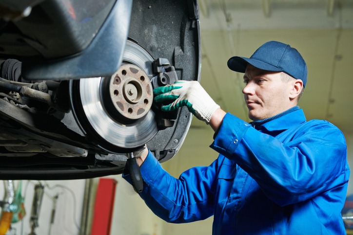 Auto mechanic at car suspension repairing