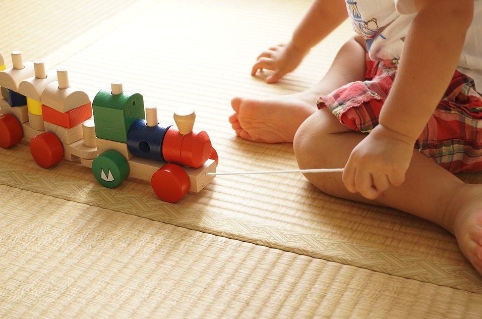 child pulling a toy train to move