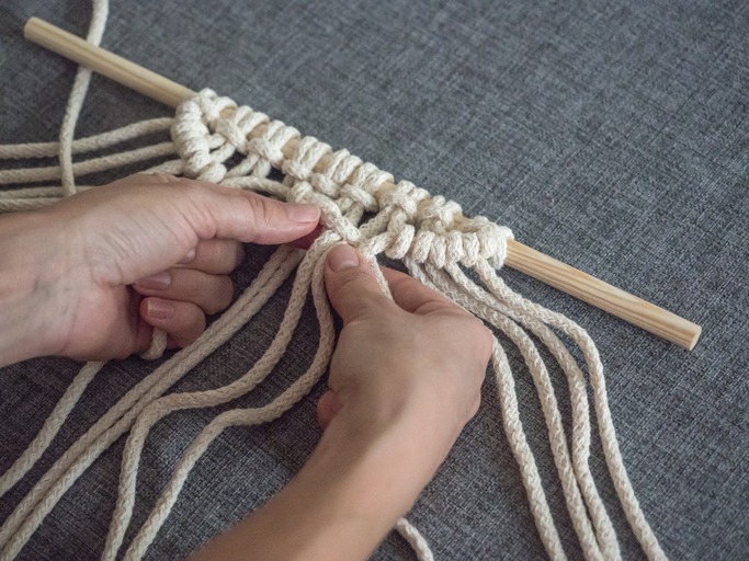 A girl weaving using Macrame