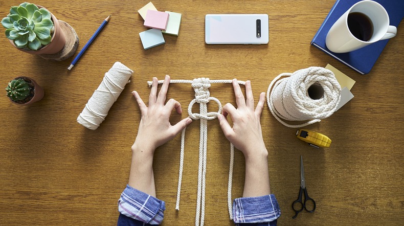 Young woman working on Macrame technique