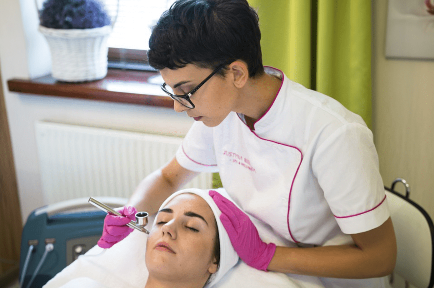 girl in white uniform, face of the girl being treated, pink gloves, white cloth