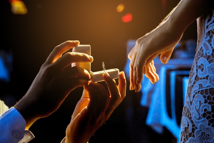 Man open a ring box to give a gift to his girlfriend.