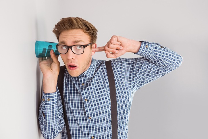 Geeky businessman eavesdropping with cup