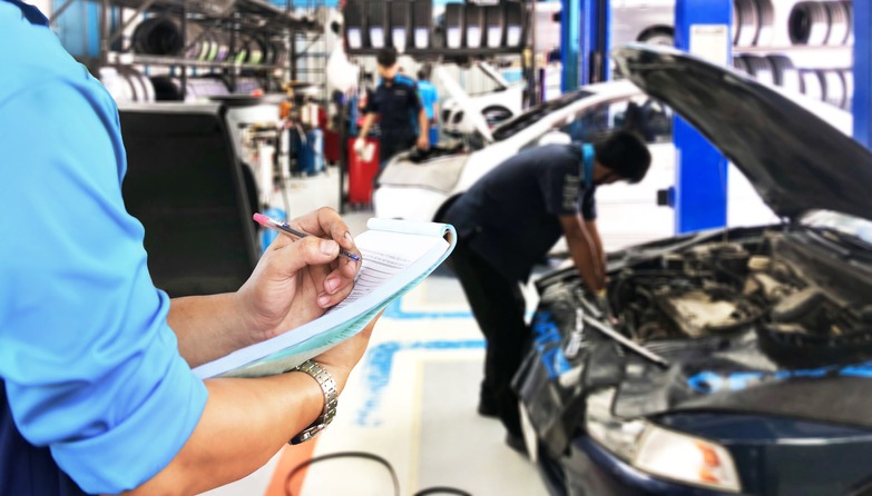 Mechanic checks the engine repair list at the garage