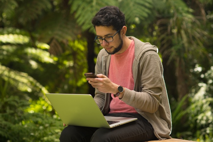 Young man with a laptop and smartphone