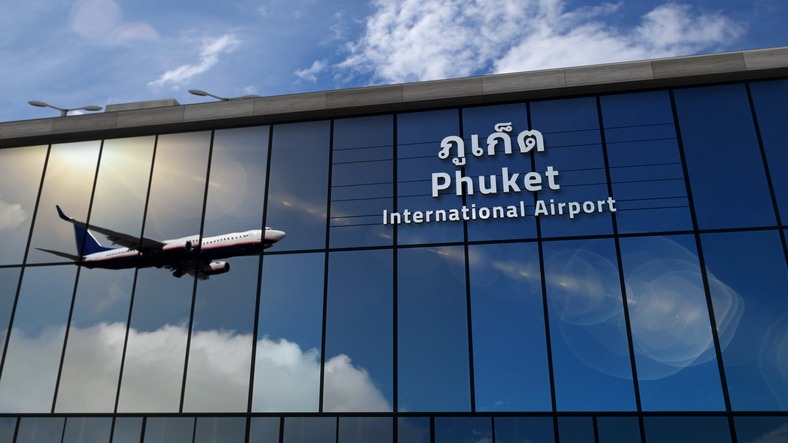 Airplane landing at Phuket Thailand airport mirrored in terminal