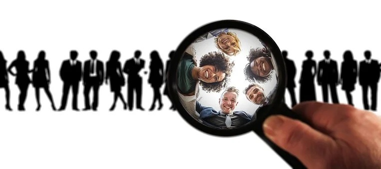 Five people looking through a magnifying glass