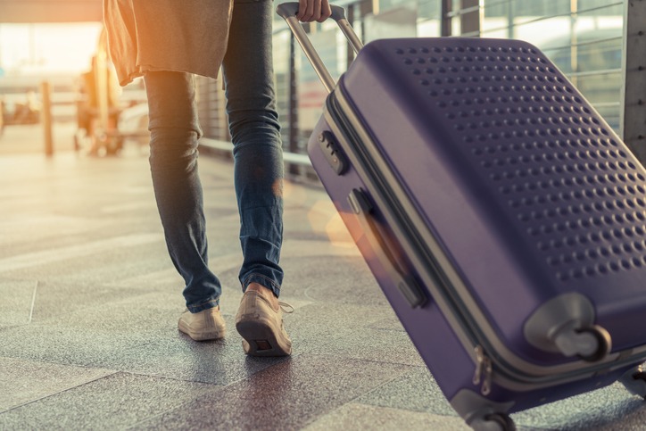 Traveler with suitcase in airport concept.Young girl  walking with carrying luggage and passenger for tour travel booking ticket flight at international vacation time in holiday rest and relaxation.