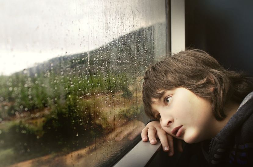 boy waiting, staying indoors, rainy weather, looking out the window, water droplets, raindrops