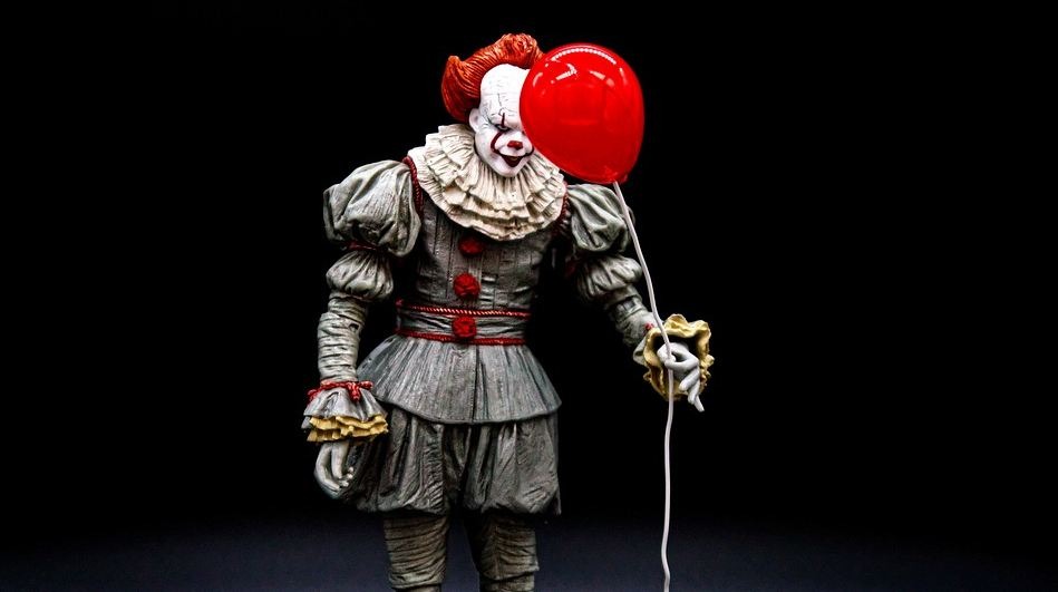 scary clown holding a balloon