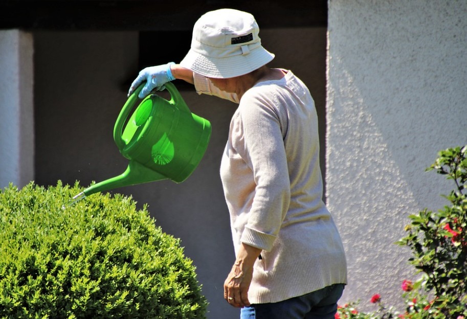 wearing a boonie hat while watering plants
