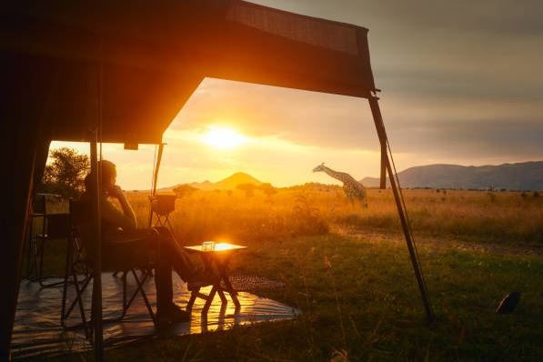 woman-rests-after-safari-in-luxury-tent-during-sunset-camping