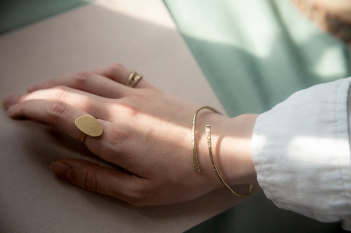 Female hand with brass Copper bracelet and gold vintage stylish polished ring