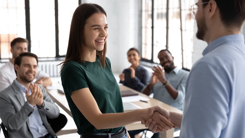 Male boss handshake female employee greeting with success at meeting