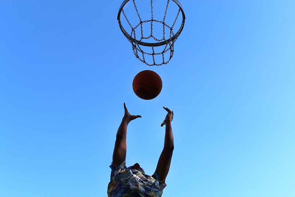a person throwing a ball to the basket.